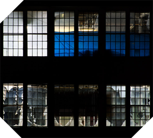 abandoned factory through lit windows at night