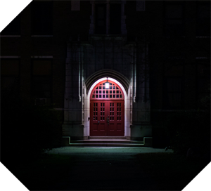 lit doorway of a dark building at night